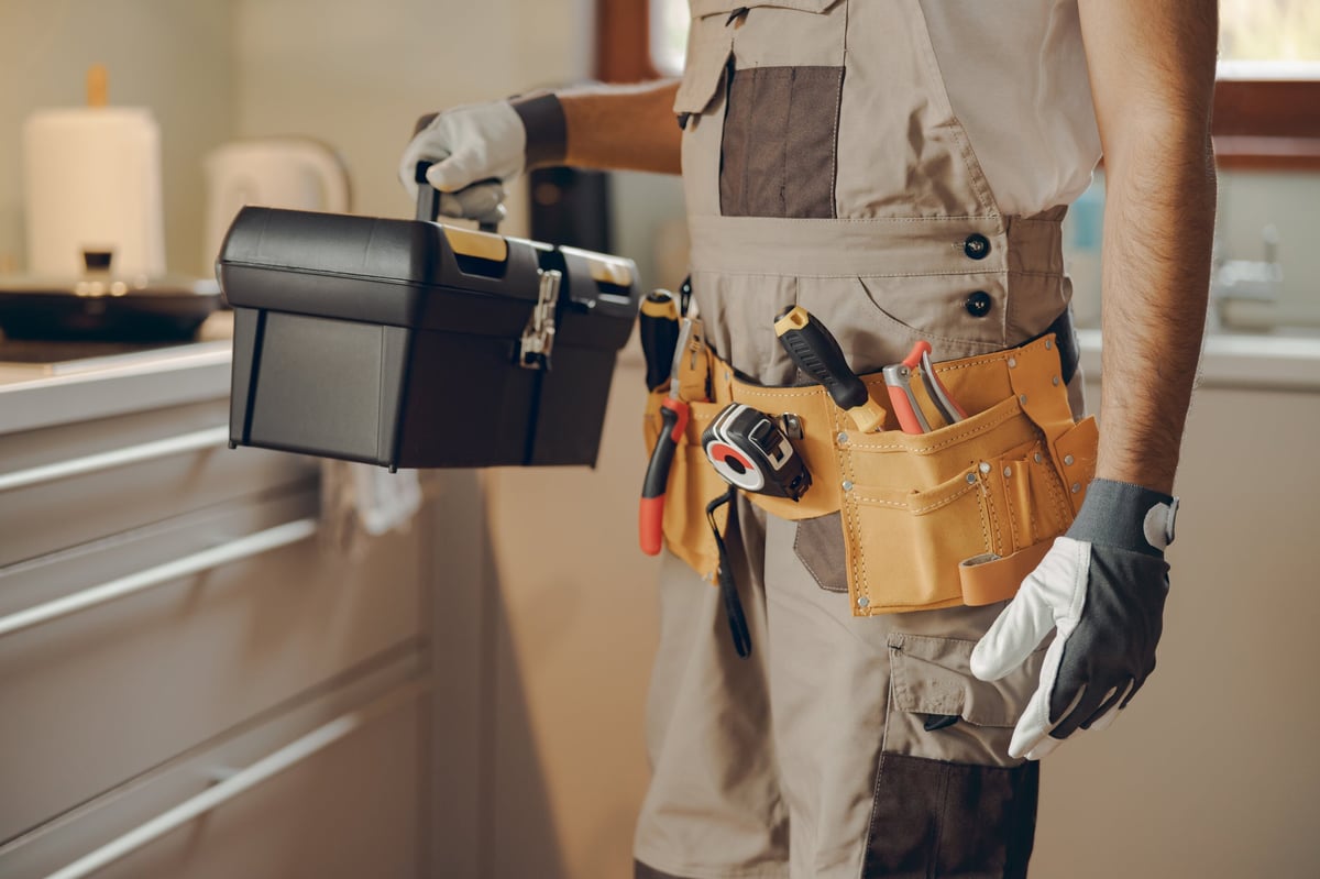 Handyman contractor holding a tool bag in a home